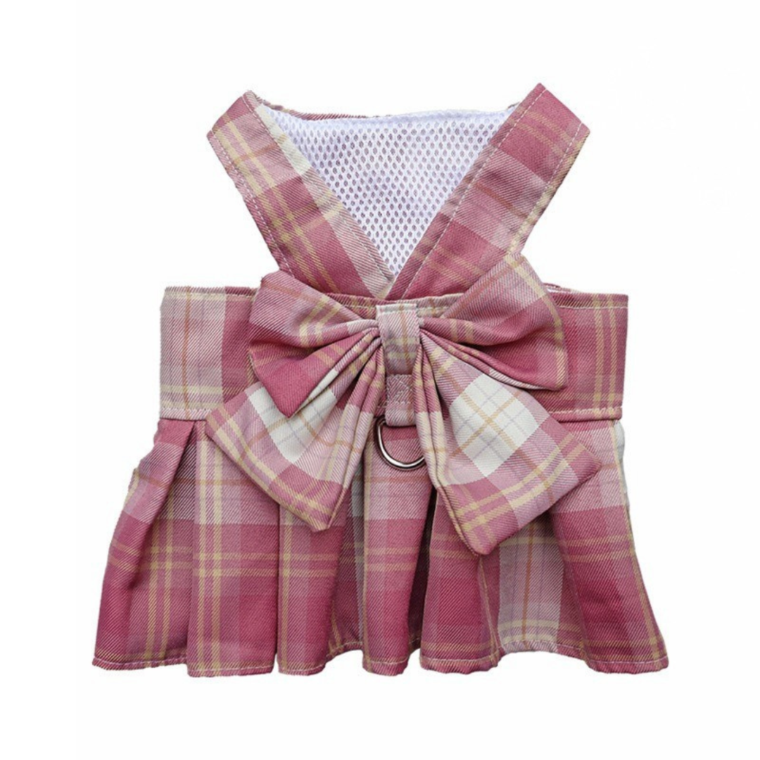 Pink plaid dog harness with a large bow on a white background