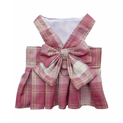 Pink plaid dog harness with a large bow on a white background