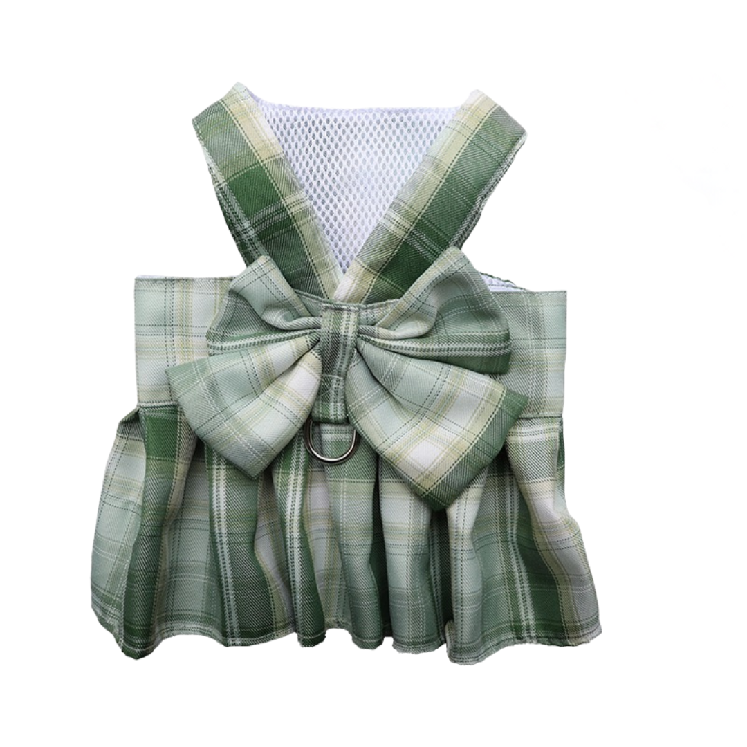 Green plaid dog harness with a large bow on a white background
